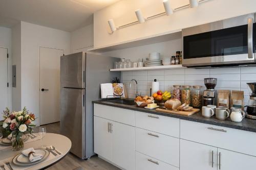 a kitchen with white cabinets and a counter with a table at Court Square Hotel Long Island City New York , Belvilla District 6 Formerly Sonder in Long Island City