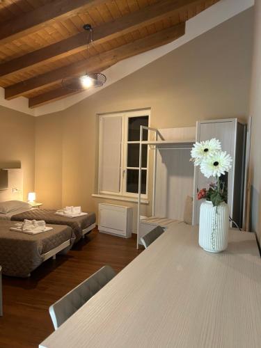 a room with two beds and a table with a vase of flowers at Hotel Ristorante Fontana in Calestano