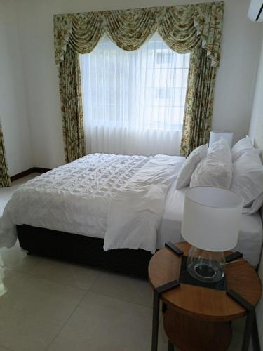 a bedroom with a bed with a window and a table at Gorgeous One Bedroom Apartment in Kingston