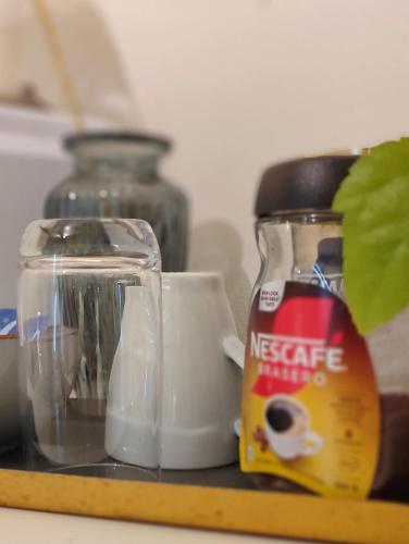 a table with a jar of coffee and a cup and a plant at Førde sentrum - Lindbøen Gjesterom in Førde