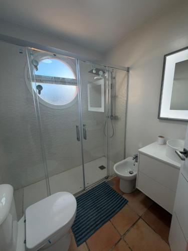 a bathroom with a shower and a toilet and a sink at Galia costa ballena 2 in Cádiz