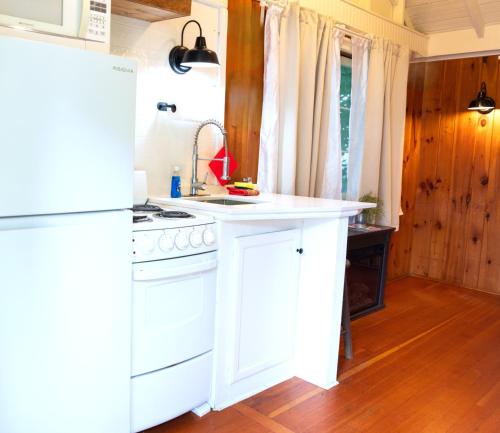 a kitchen with a white stove and a white refrigerator at Cottage 1-2 -2 Bedroom 1 Bath End Unit with Kitchenette Private Courtyard Pet Friendly fee applies in Wolfeboro