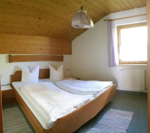 ein Schlafzimmer mit einem Bett in einem Zimmer mit einem Fenster in der Unterkunft Apartmenthaus Immler in Gaschurn