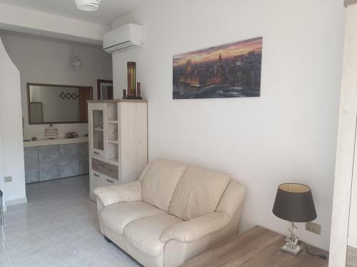 a living room with a white couch and a television at Mare e Città in Selargius