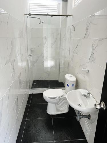 a white bathroom with a toilet and a sink at Hotel villa dulce campestre in Melgar