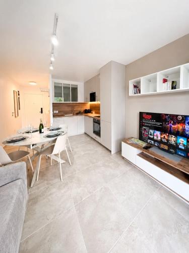 a living room with a table and a kitchen at Refuge des Plages-T3 neuf climatisé - Terrasse Sud - proche mer et port à Fréjus in Fréjus