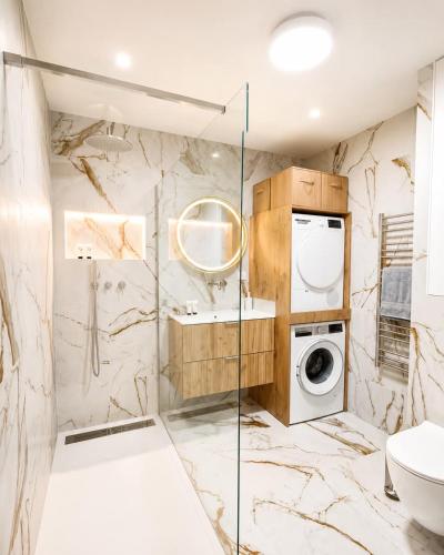 a bathroom with a washing machine and a washer and dryer at Refuge des Plages-T3 neuf climatisé - Terrasse Sud - proche mer et port à Fréjus in Fréjus