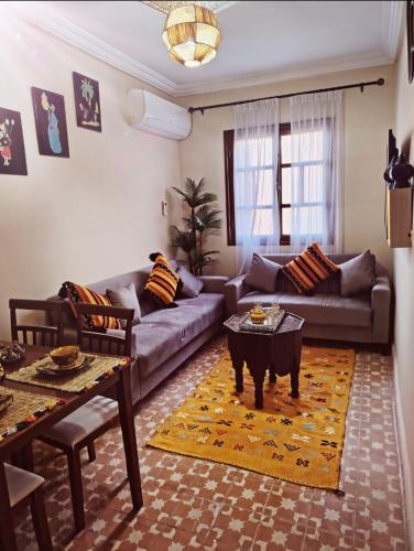 ein Wohnzimmer mit Sofa und Tisch in der Unterkunft PalmRest in Marrakesch