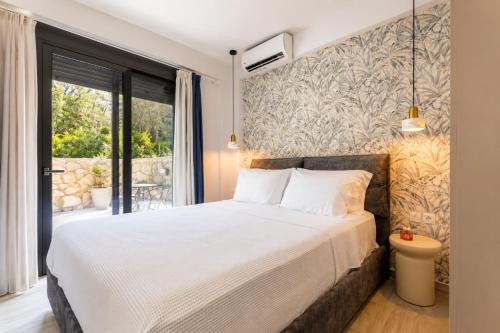 a bedroom with a bed and a large window at Charisma apartments in Nikiana