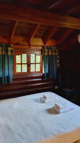 a bedroom with a bed with two towels on it at Casita de Belén in Merlo