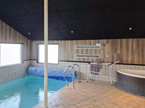 a bathroom with a swimming pool and a tub at 4 star holiday home in Vinderup in Vinderup