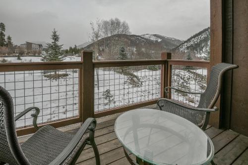 a table and chairs on a balcony with a snow covered mountain at Frey Gulch 58 by SummitCove Lodging in Colorado in Keystone