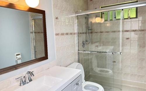 a bathroom with a shower and a toilet and a sink at Joe West Vancouver Lodge in West Vancouver