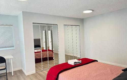 a bedroom with a mirror and a bed with a red blanket at Joe West Vancouver Lodge in West Vancouver