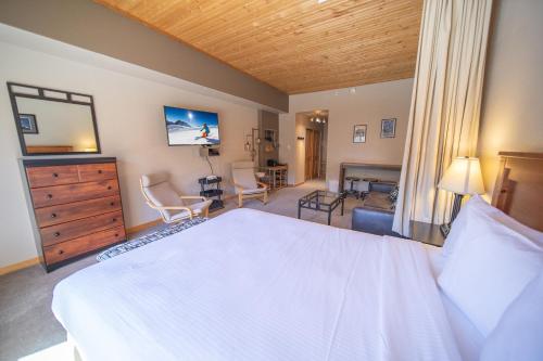 a bedroom with a large white bed and a living room at Gateway Lodge 5054 by SummitCove Lodging in Colorado in Keystone