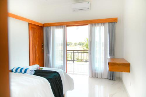 a bedroom with a bed and a window with a balcony at Villa Bagus in Lovina