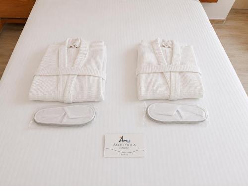 a pair of white socks and shoes on a bed at Anthoula House Sarti in Sarti