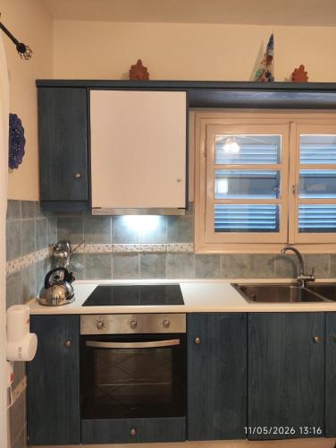 a kitchen with wooden cabinets and a sink at Villa Galazia in Megalochori