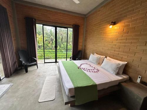 a bedroom with a large bed with a brick wall at Blue Horizon By Capt Logus in Ja-Ela