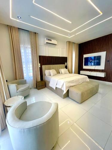 a large bedroom with a bed and a tub in it at Prince-Coll apartment in Lagos
