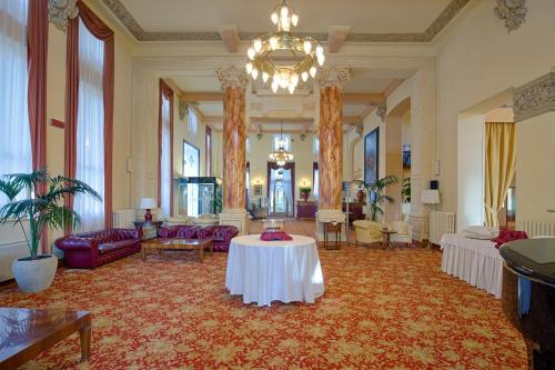 a large room with a table in the middle of it at Palace Grand Hotel Varese in Varese