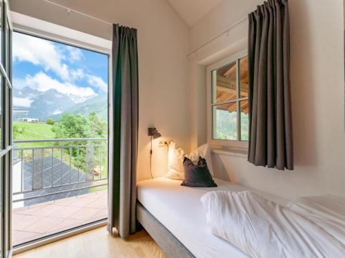 a bedroom with a bed and a balcony at Haus Aifnerspitze in Kauns