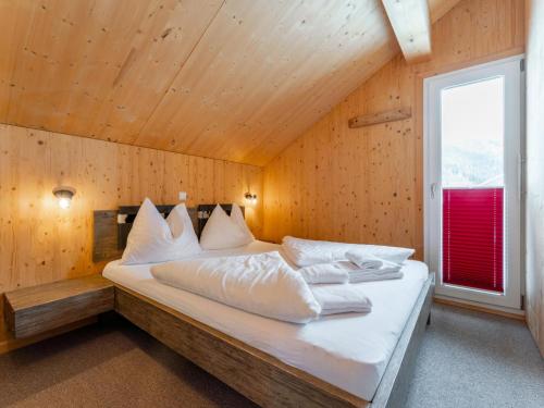 a bedroom with a bed in a room with a window at Lachende Eule in Hohentauern