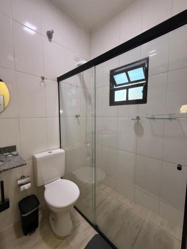 a bathroom with a toilet and a glass shower at São Hostel in São Roque