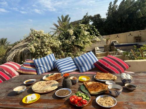 a wooden table with plates of food on it at مبيت في الصحراء in Tunis