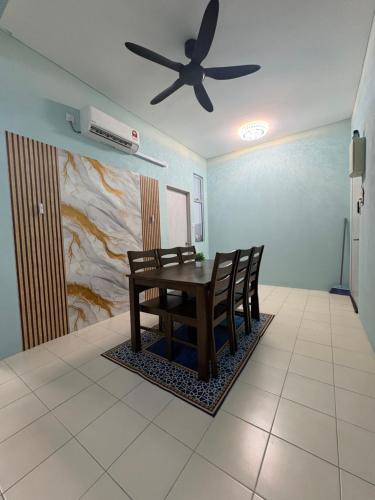 a dining room with a table and a ceiling fan at Aileen Homestay in Tawau