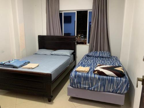 a bedroom with two beds and a window at Hostal Belletini in Manta