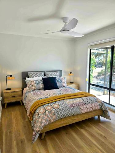 a bedroom with a bed and a ceiling fan at Cygnet Escape in Cygnet River