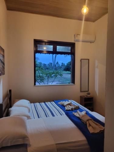 a bedroom with two beds and a window at Chácara Amsterdam in Aracaju