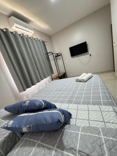 a bedroom with two beds with pillows and a flat screen tv at Casa elegante, próximo às cataratas in Foz do Iguaçu