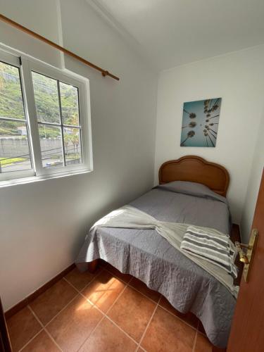 a bedroom with a bed and two windows at Rdj A in Porto Moniz