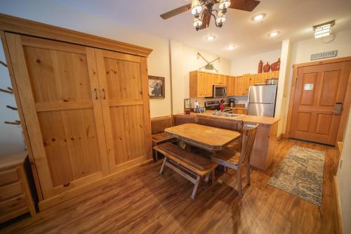 a kitchen with wooden cabinets and a wooden table at Expedition Station 8554 by SummitCove Lodging in Colorado in Keystone