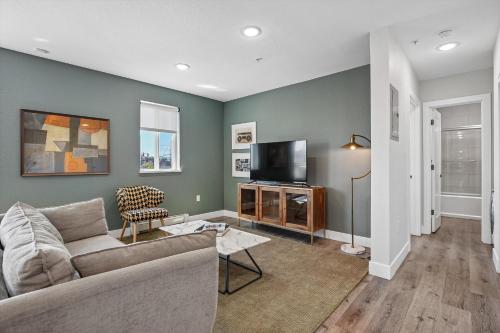 a living room with a couch and a tv at Kasa LoHi Denver in Denver