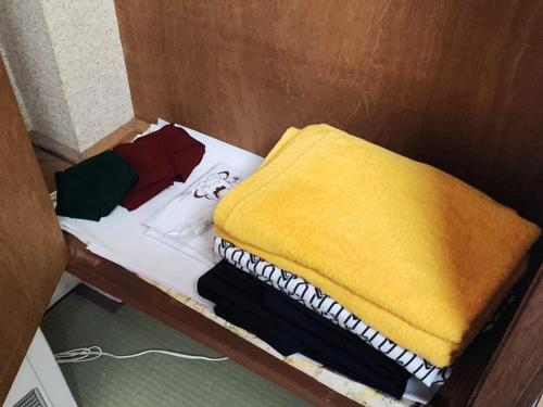 a small bed with a yellow blanket on it at 湯畑源泉宮崎館 in Kusatsu