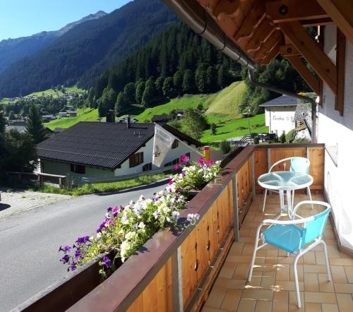a balcony with flowers and a table and chairs at Apartmenthaus Immler in Gaschurn