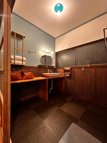 a bathroom with a sink and a mirror at IPPONMATSU Private Villa - 宮崎の古民家一棟貸し 一本松 in Miyazaki