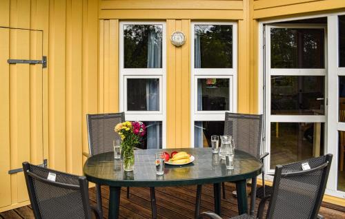 a table with a plate of fruit and a vase of flowers at Frische Brise 3 - Dorf 2 in Priwall