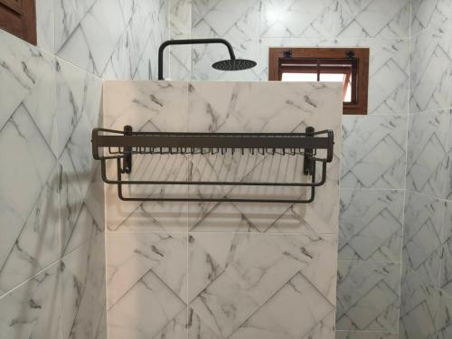 a towel rack in a bathroom with white marble at นนท์ ณ in Ban Non Makhuk