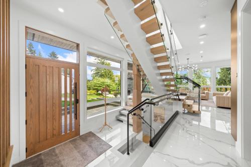an open hallway with a wooden door and a living room at North Shore Luxe Villa in North Vancouver