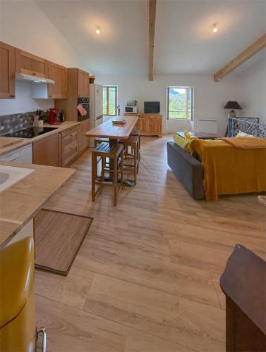 a kitchen and living room with a couch and a table at Maison de campagne T3 Nature in La Martre