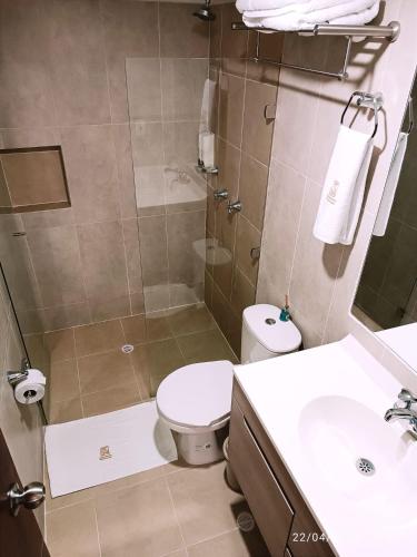 a bathroom with a shower and a toilet and a sink at Apartamentos Quedate en Anavi San Gil Plaza in San Gil