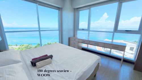 a bedroom with a bed with a view of the ocean at La Mirada Residences in Mactan