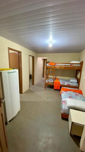 a room with three bunk beds and a refrigerator at Sítio Relax in Tianguá