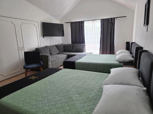 a living room with two beds and a couch at 24 Habitación doble cama in Miravalle