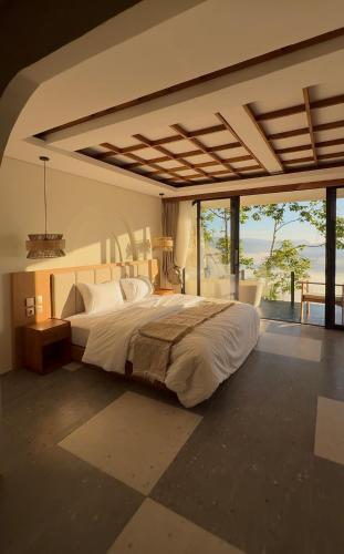 a bedroom with a large bed and a large window at The Casa Lunamoon in Kintamani