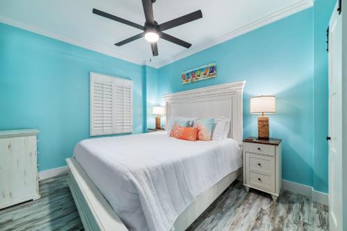 a blue bedroom with a bed and a ceiling fan at BeachFront, Bottom Level Condo at Tradewinds in Orange Beach